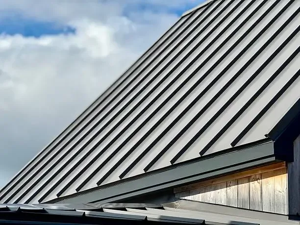 Standing seam metal roof slope above a wood soffit